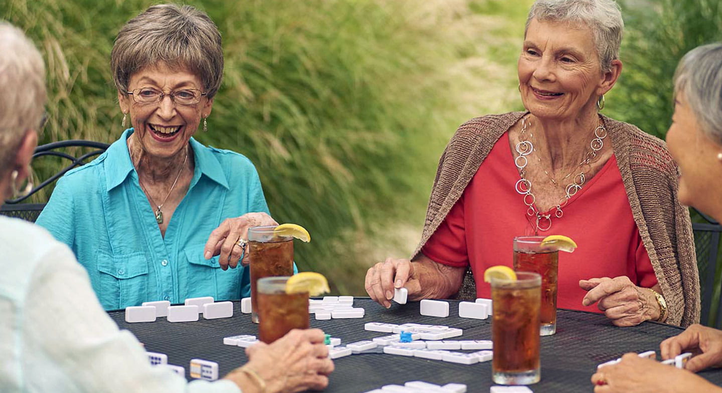 Adult woman playing dominoes and drinking ice tea