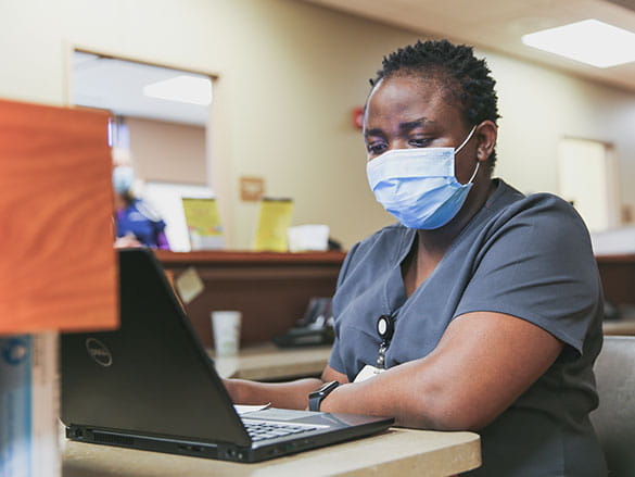 Masked nurse with laptop